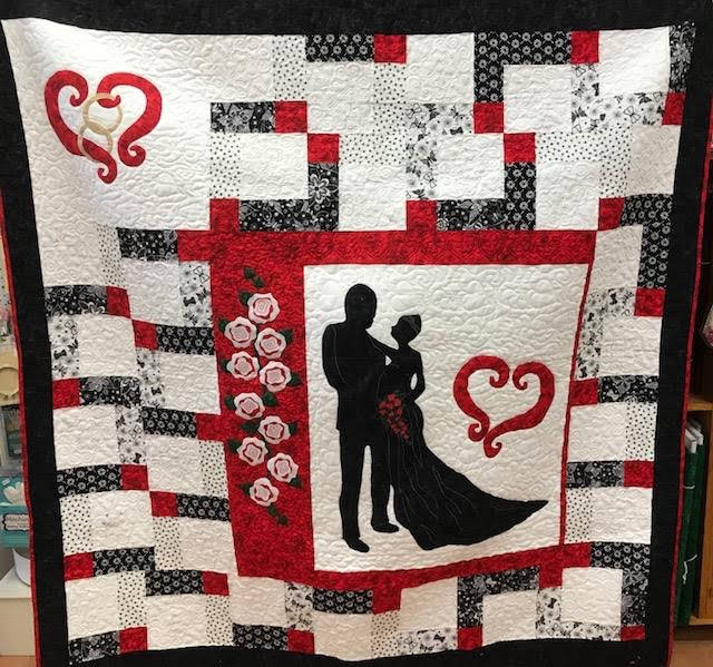 An absolutely stunning wedding quilt, made with squares inscribed by the guests.